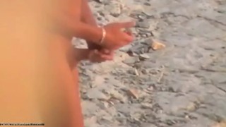 Un hombre pajeándose en la playa